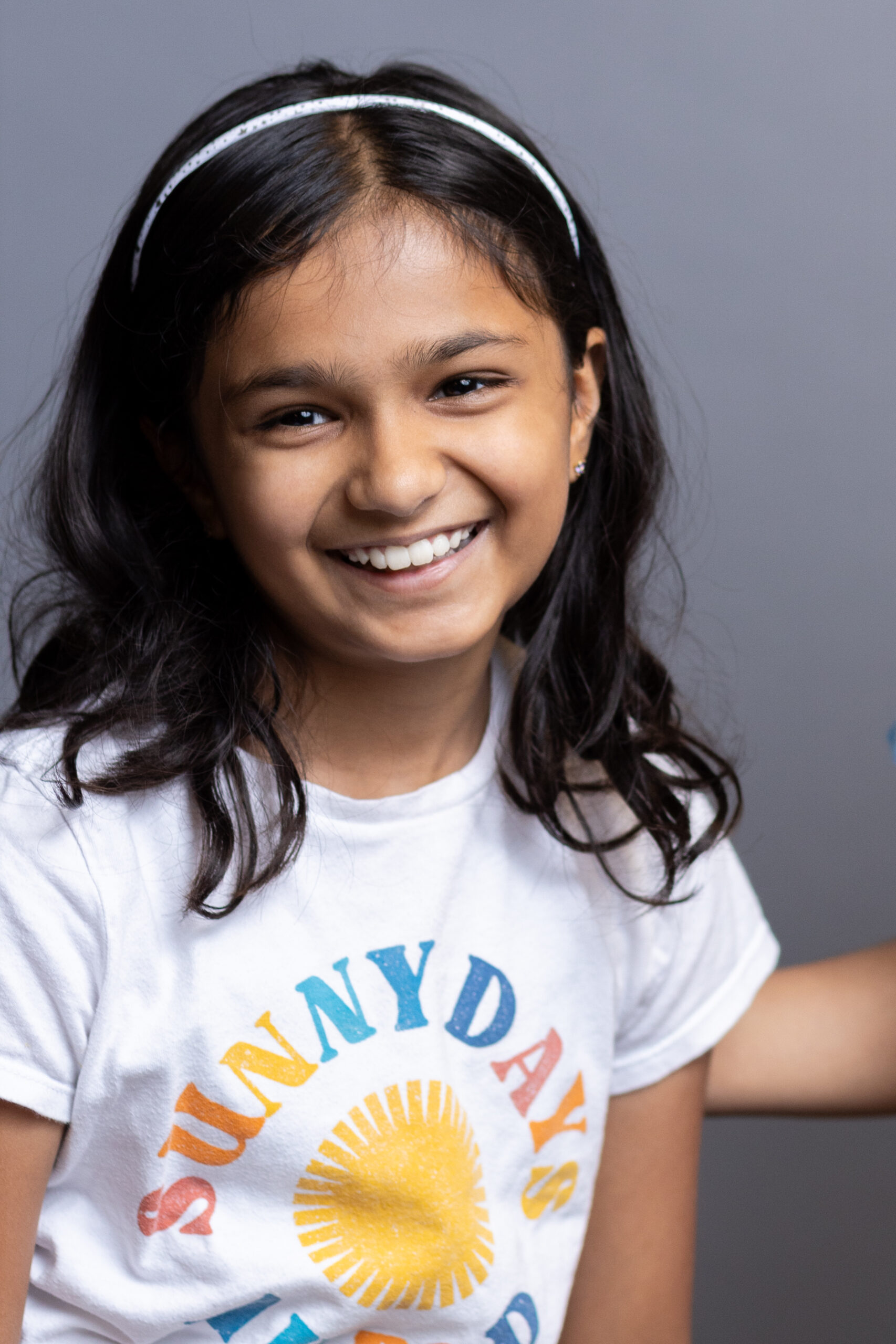 A child is smiling and posing at Bastian Orthodontics for Kids.