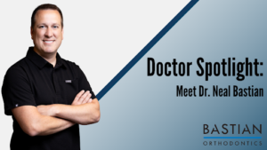 Smiling man in black polo beside Doctor Spotlight Meet Dr. Neal Bastian text