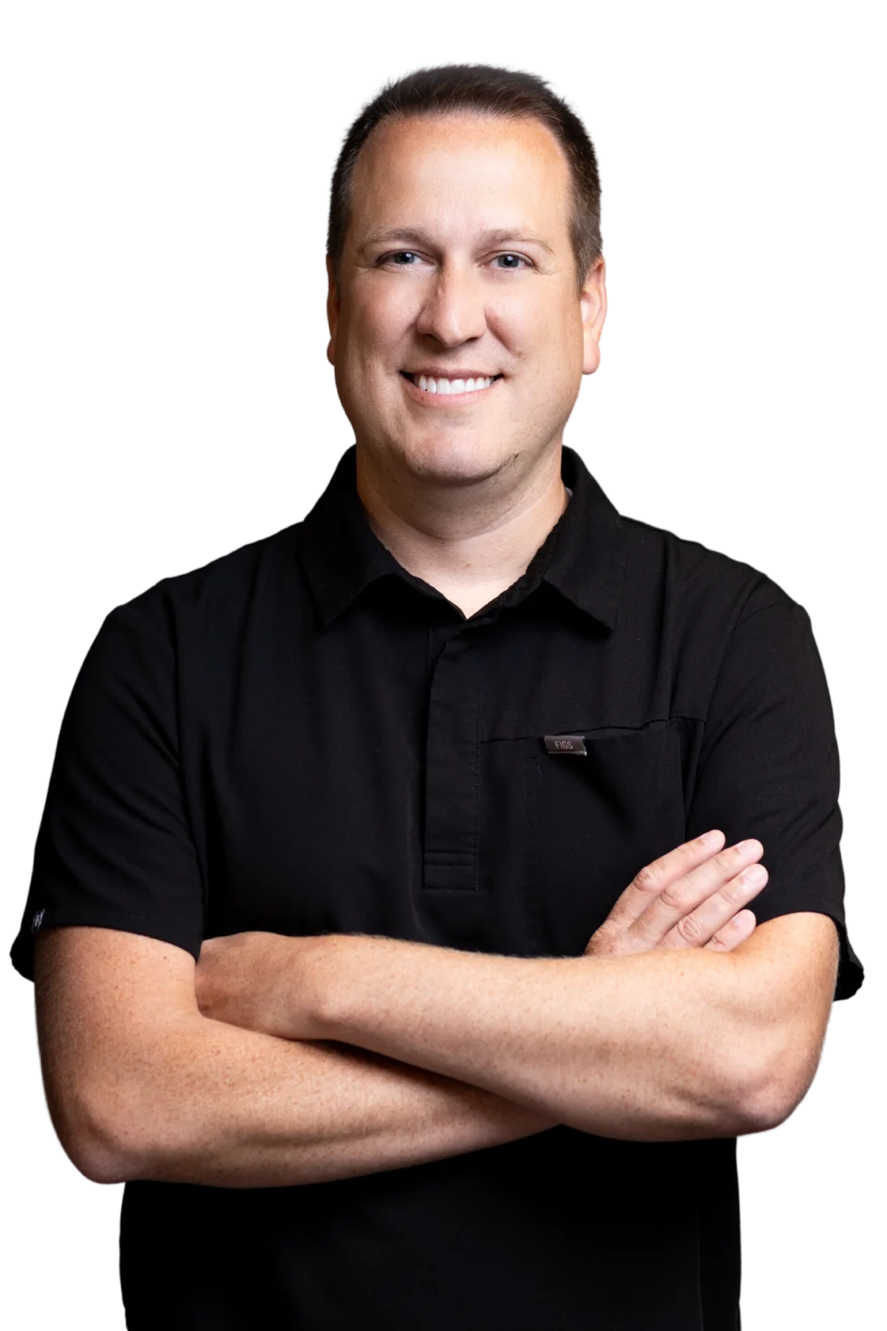 Dr. Bastian, smiling with arms crossed, in a black scrub top